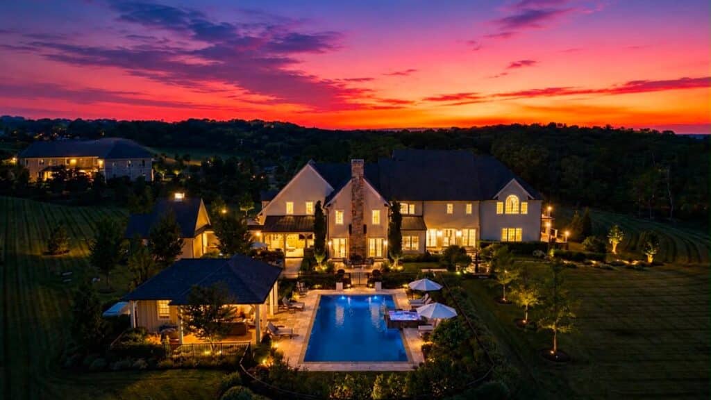 A luxury Bucks County home exterior with landscaped grounds at dusk