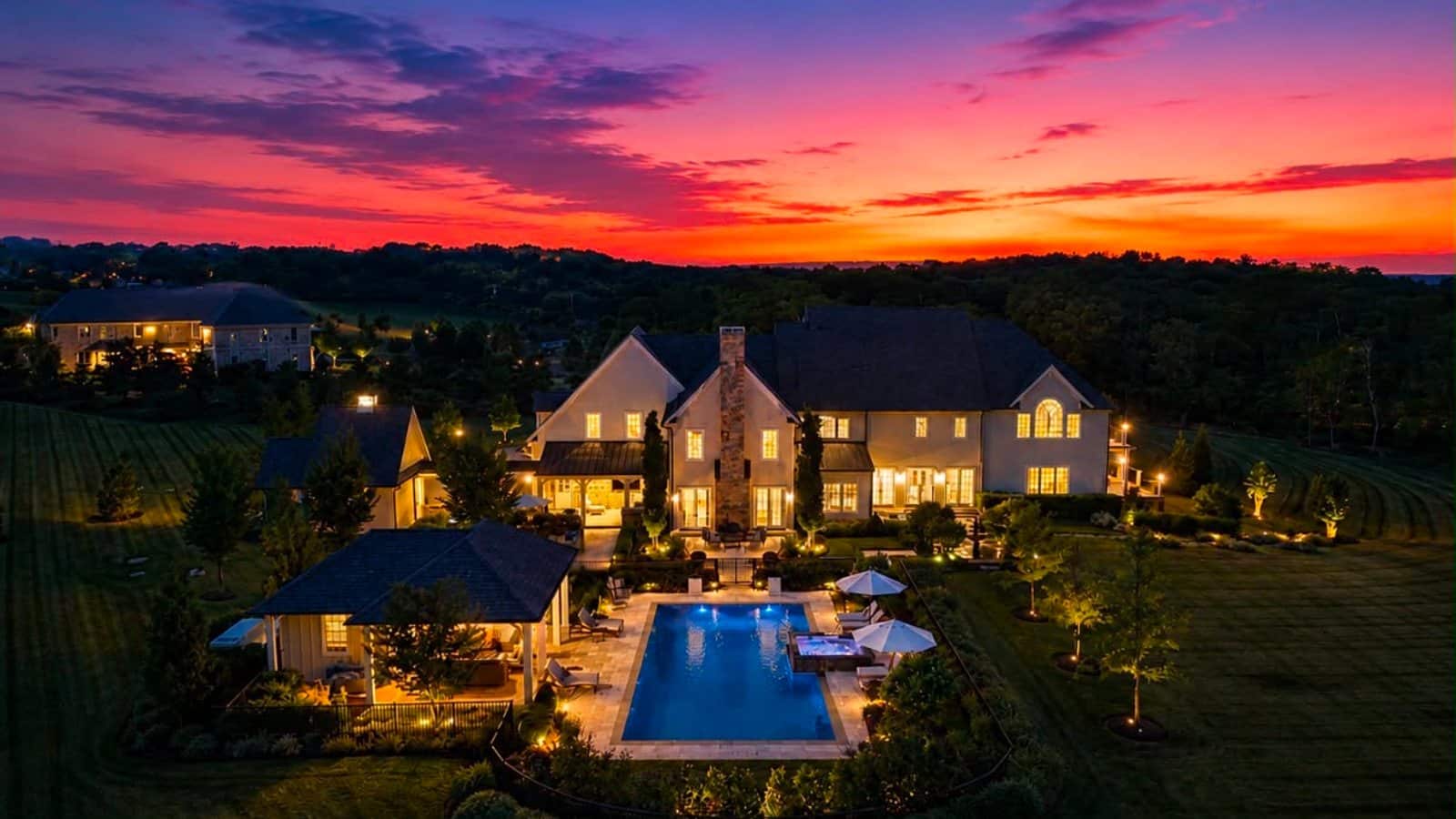 A luxury Bucks County home exterior with landscaped grounds at dusk